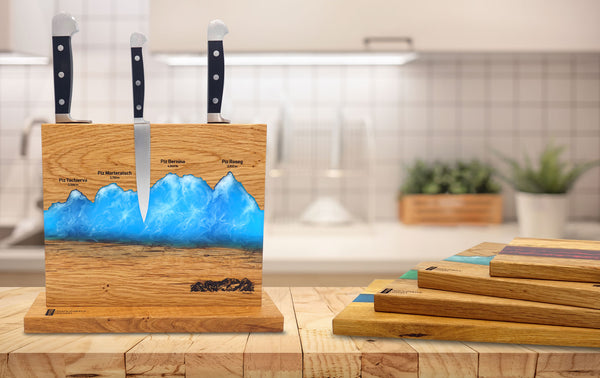 Magnetische Messerhalter der Manufaktur Nissen aus Eichenholz mit Silhouette des Oberengadins und Veredelung aus Epoxidharz  und Servierbretter aus Eichenholz mit farbigem Epoxidharz in der Küche