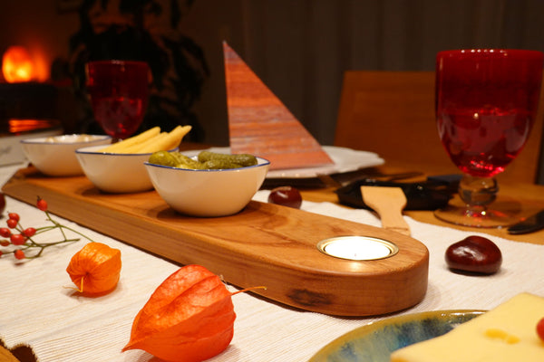 feierlich gedeckter Tisch mit handgefertigtem Apéro-Set der Manufaktur Nissen aus schweizer Ulmenholz mit integriertem Teelichthalter und 3 veganen Porzellanschälchen