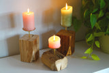Übersicht von handgefertigten Kerzenständern der Manufaktur Nissen aus Altholz und einer Tropfschale aus Messing mit brennenden Stumpenkerzen