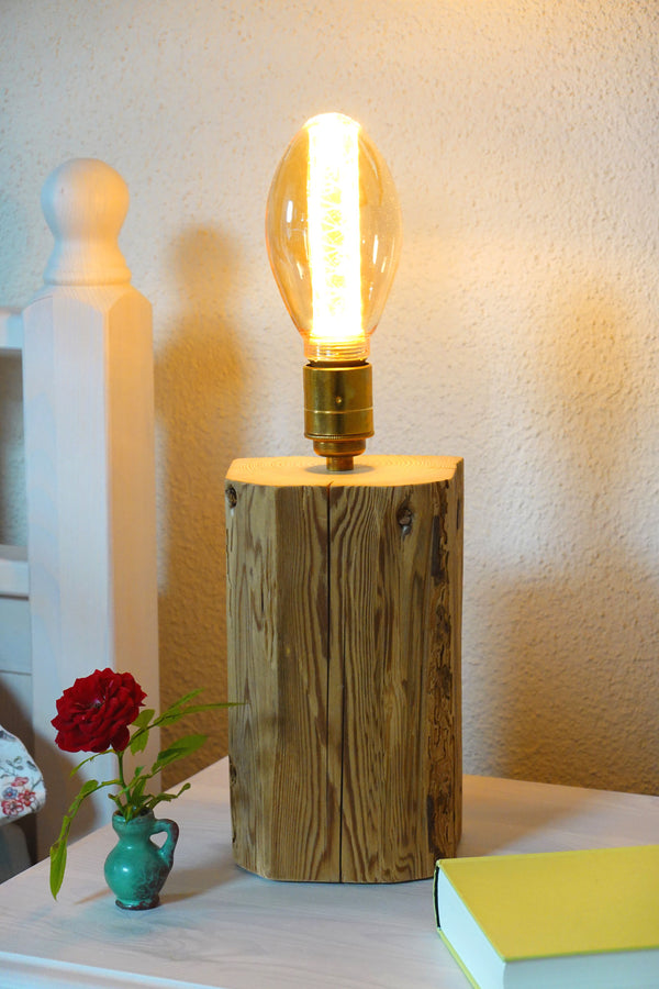 Retro Leuchte aus Altholz der Manufaktur Nissen mit Metallfassung, hochwertigem Textilkabel und Vintage Leuchtmittel auf Nachttisch