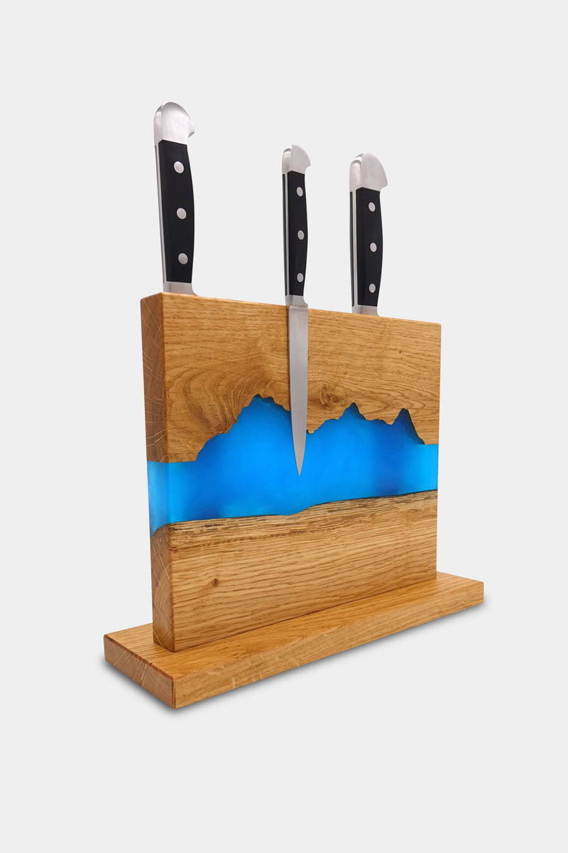 Hochwertiger magnetischer Messerhalter der Grösse M der Manufaktur Nissen aus schweizer Eichenholz in der Rückansicht mit Silhouette des Berner Oberlandes und blauer Veredelung aus biobasiertem Epoxidharz