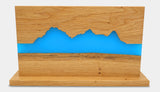 Hochwertiger magnetischer Messerhalter der Grösse L der Manufaktur Nissen aus schweizer Eichenholz in der Rückansicht mit Silhouette des Berner Oberlandes und blauer Veredelung aus biobasiertem Epoxidharz